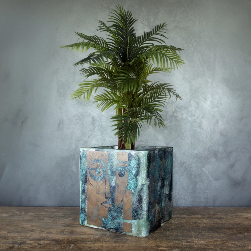 Osłonka na doniczkę z artystycznym motywem twarzy, efekt kortenu z turkusową patyną, ręcznie wykonana.