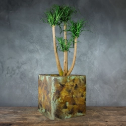 Kwadratowa osłonka na doniczkę z efektem kortenu i turkusową patyną, ręcznie wykonana i malowana, o rustykalnym charakterze.