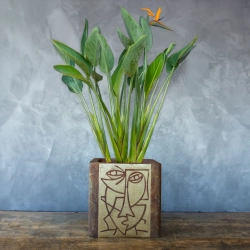 Osłonka w efekcie cortenu z geometrycznym motywem twarzy i turkusowo-zieloną patyną, dekoracyjna, kwadratowa, ręcznie wykonana.